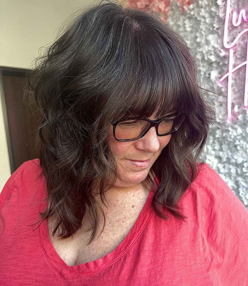 Frisuren mittellanges Haar ab 60 mit Brille: Der sanft gewellte Long Bob mit Pony